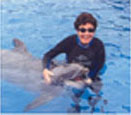 This is the second of four thumbnail photos of me swimming with and stroking a dolphin